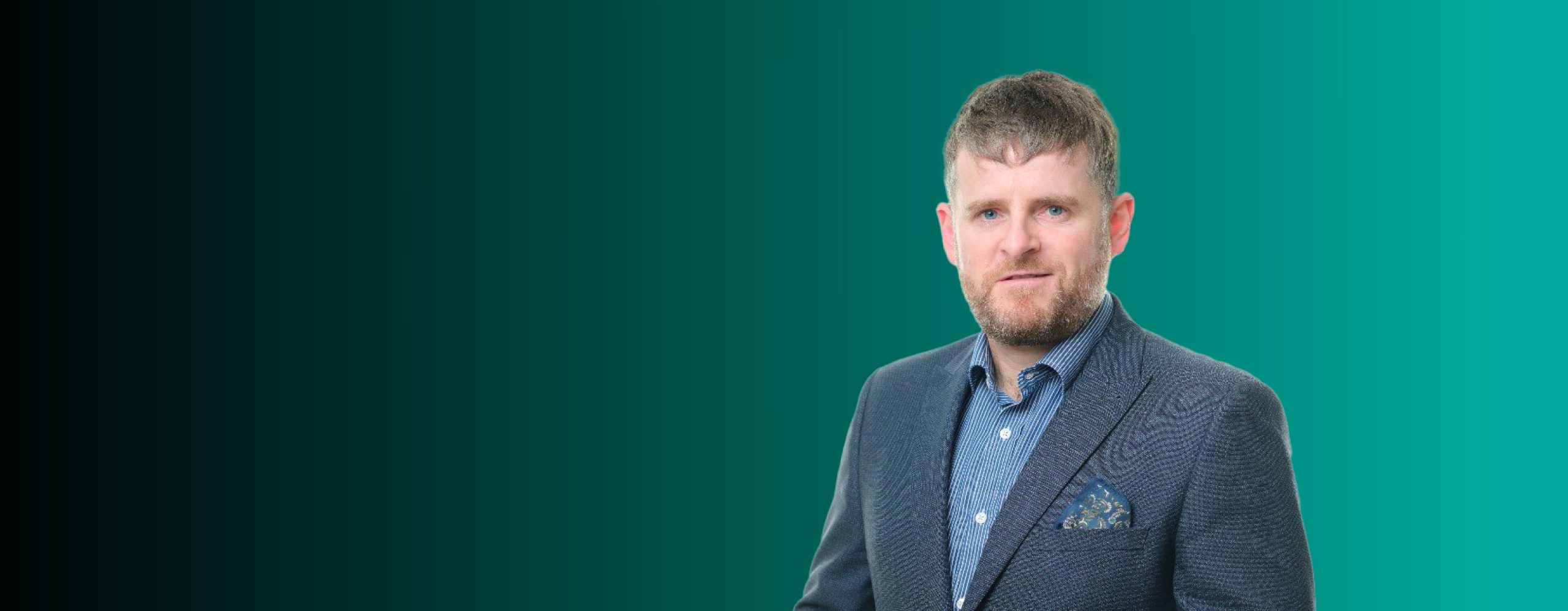 Jonathan Telling, dressed in a dark blazer and patterned shirt, stands against a gradient green background.