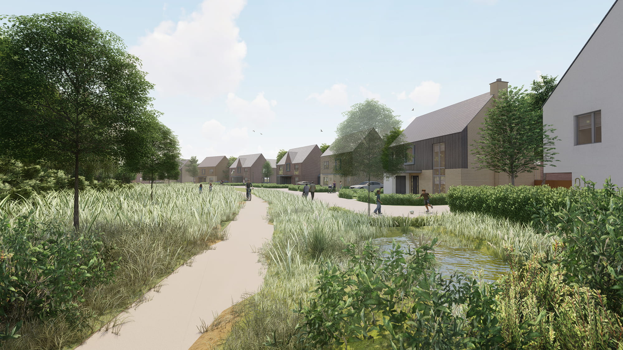 A landscaped residential area featuring modern houses, walking paths, and greenery under a clear sky.