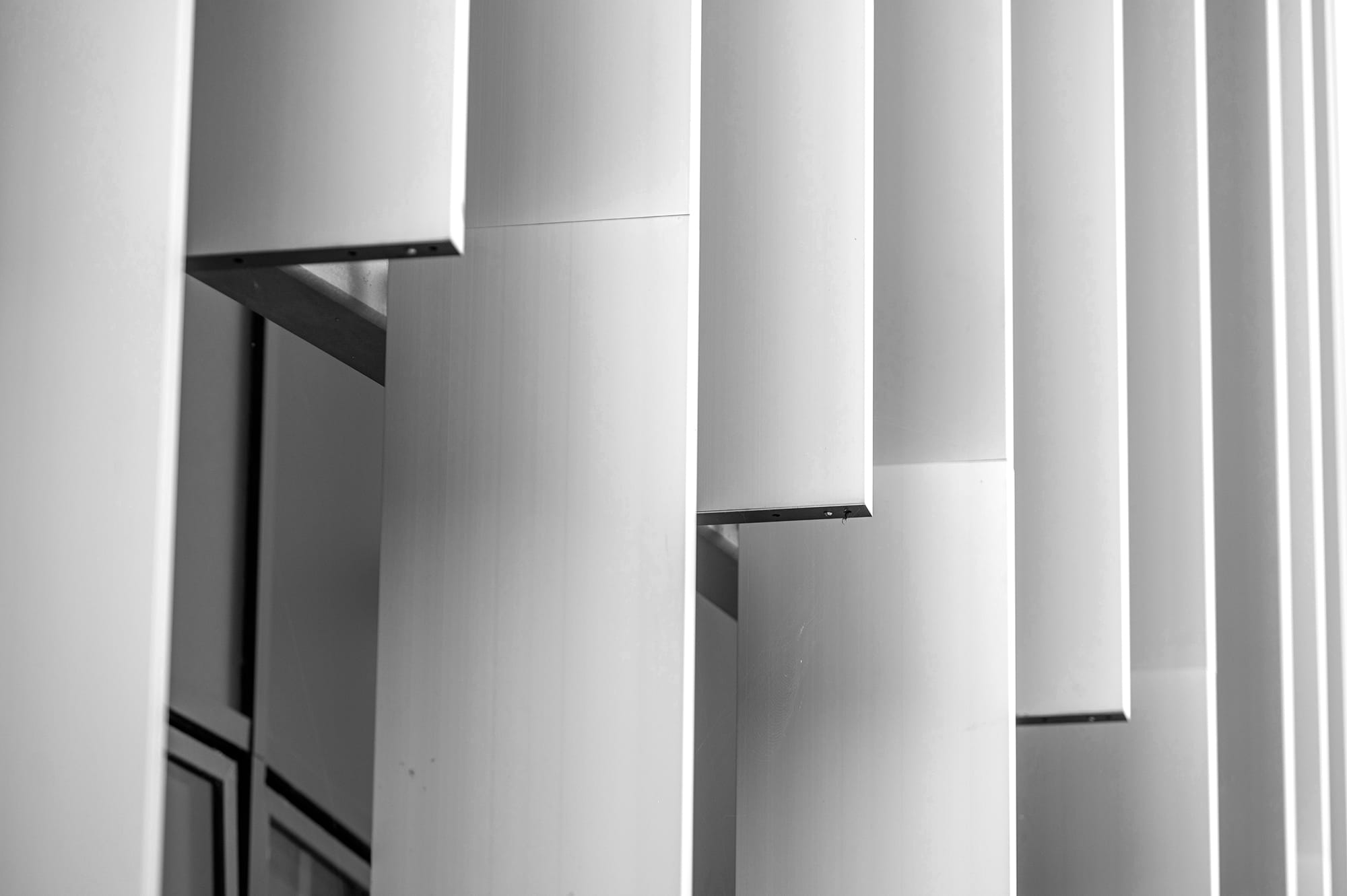 Abstract composition of vertical metal panels in varying depths and angles, creating a dynamic architectural detail.