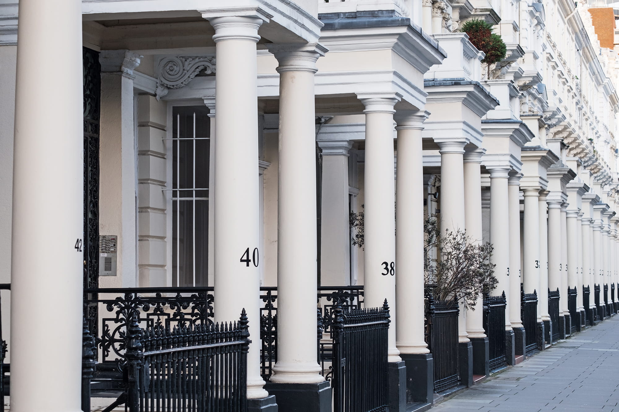 Row of elegant residential buildings featuring white columns and black railings, with visible house numbers 38, 40, and 42.