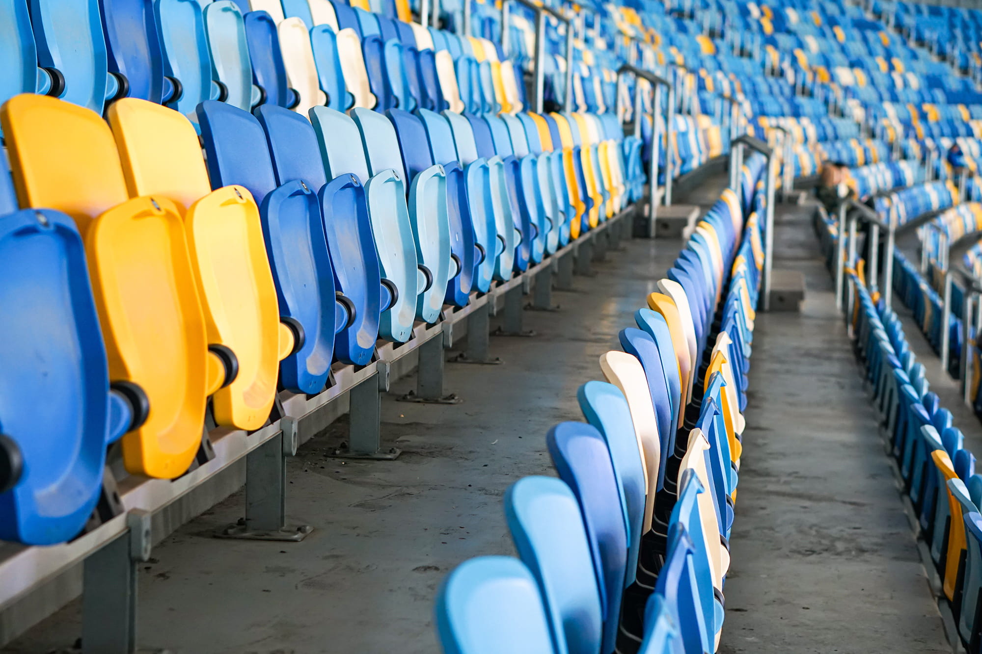 Rows of blue and yellow stadium seats arranged in a modern sports venue.