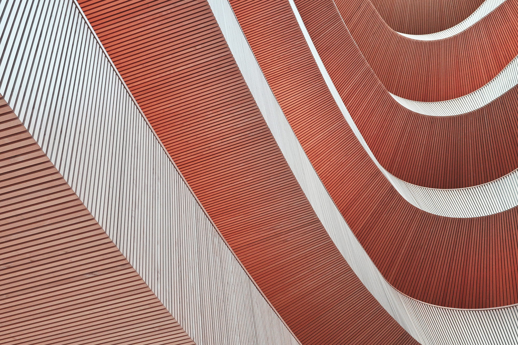 Abstract pattern of alternating red and white horizontal lines creating a wave-like effect.