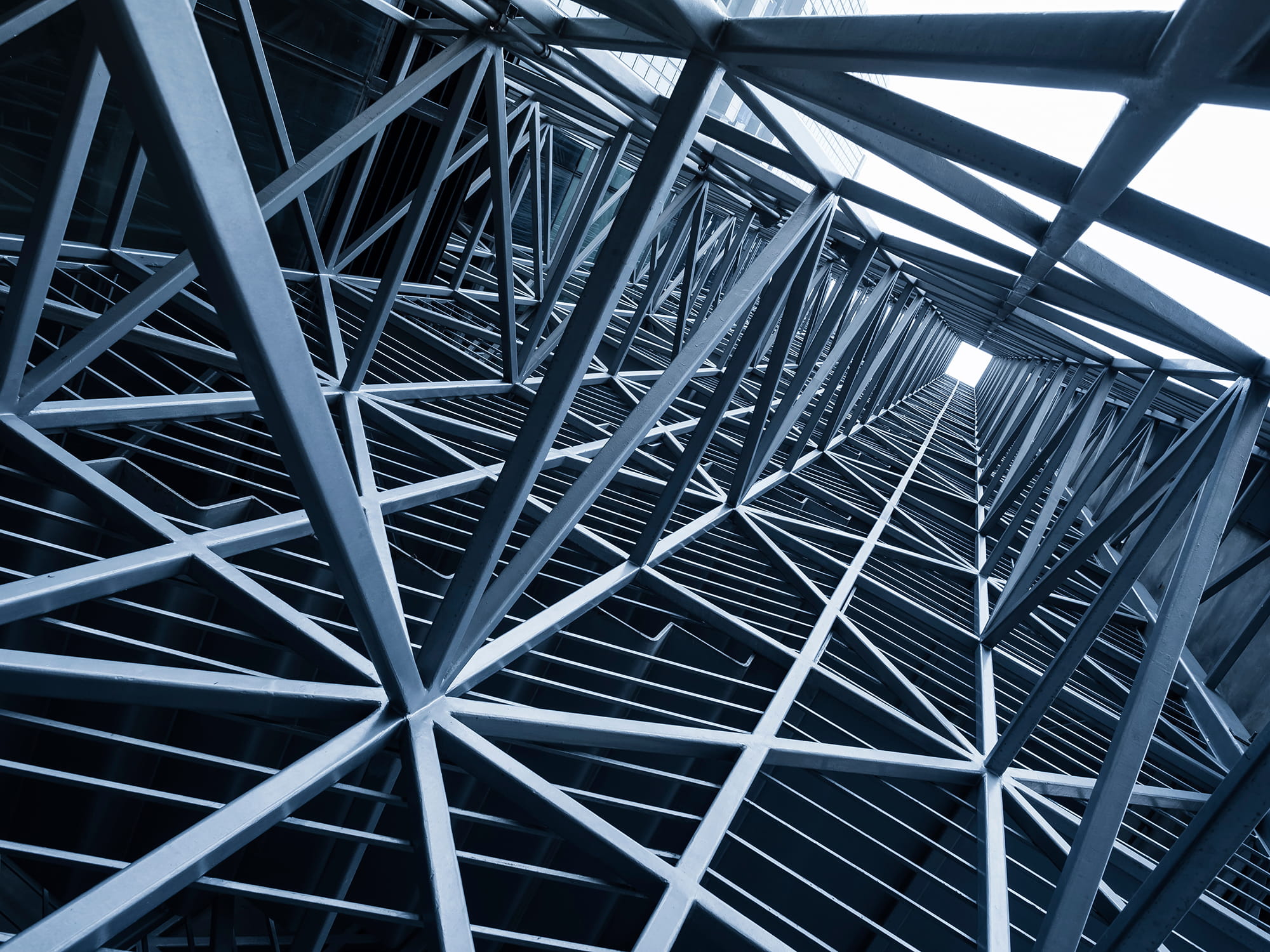 View of a structural framework with intersecting steel beams and a vertical perspective.
